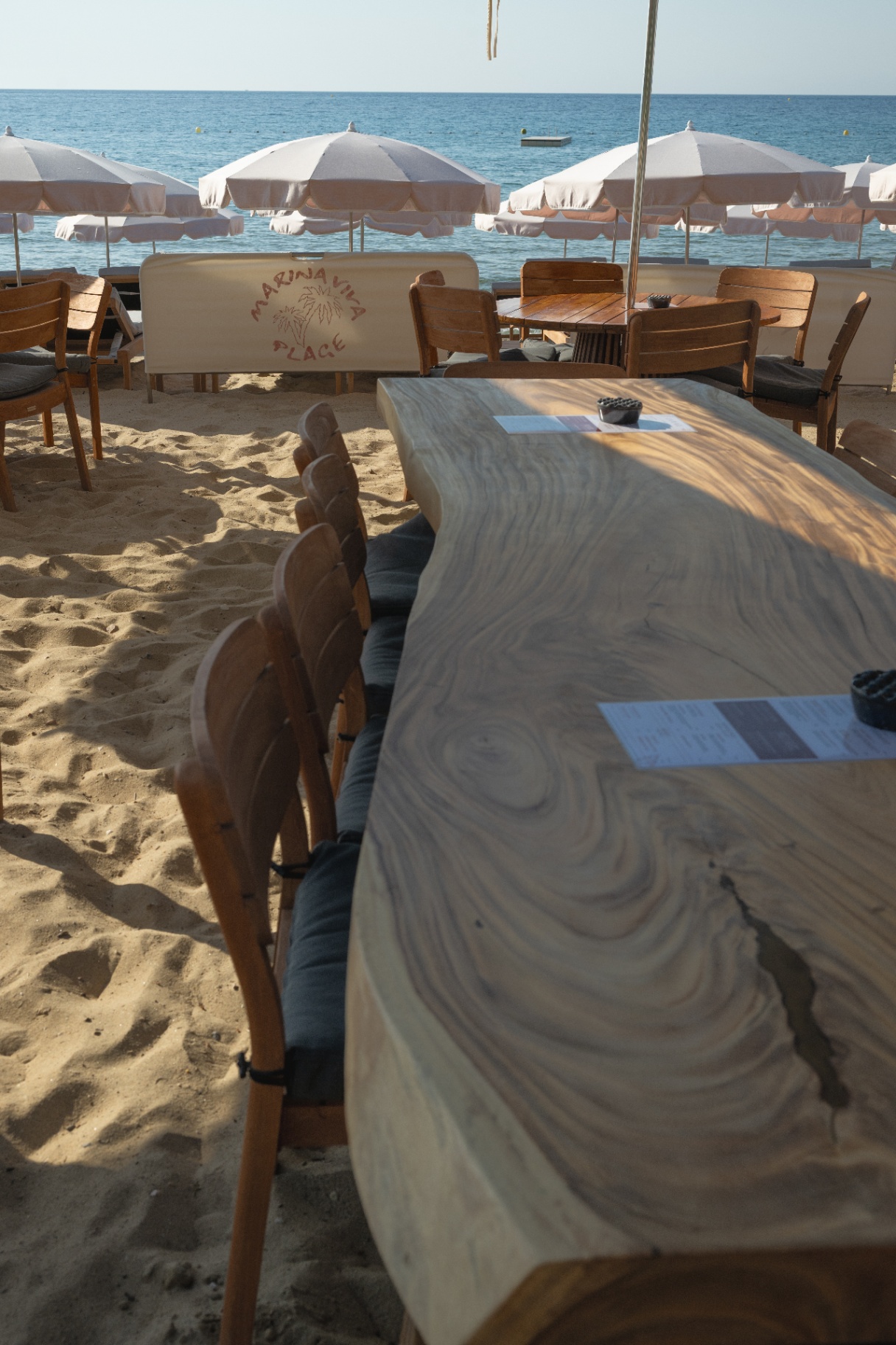 Grande table en bois brut face à la mer