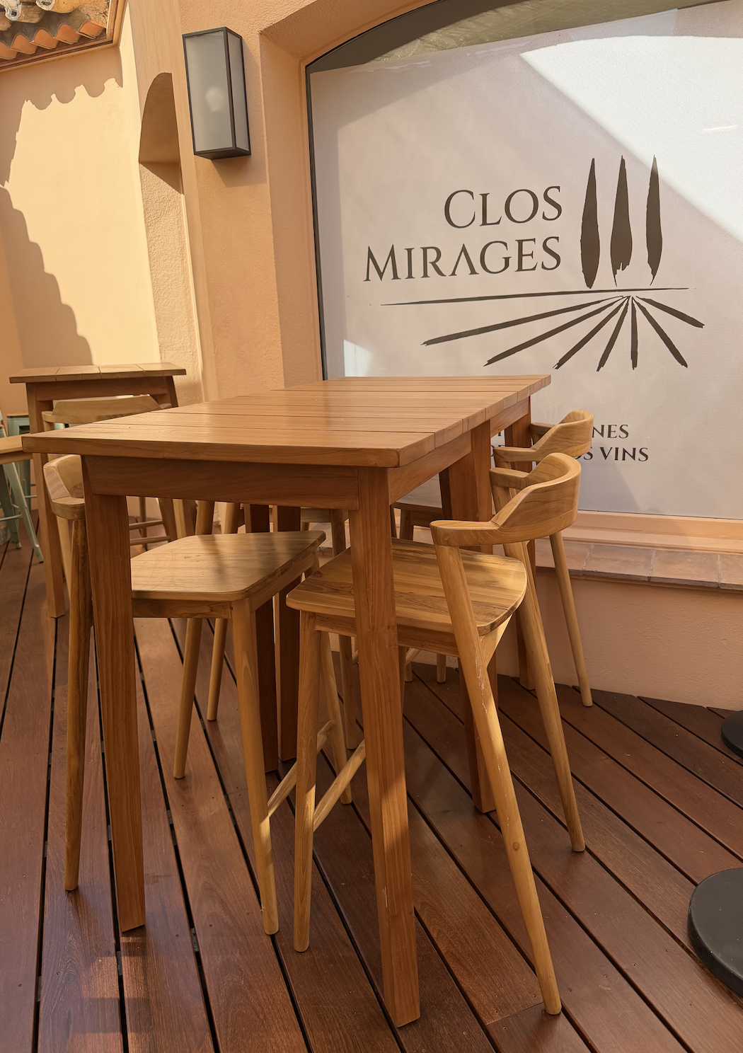 Mange-debout et tabourets en teck sur la terrasse du Clos Mirages